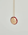 Love Necklace by MyAleph, gold disc charm with red enamel border and love script engraving, front detail view