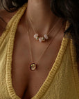 Love gold engraved necklace layered with Ava rose quartz necklace on model wearing yellow knit top, MyAleph We Are One Collection