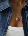 Close-up of Love gold necklace with red enamel border and love script engraving on model, MyAleph