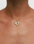Model wearing MyAleph Chai Necklace, gold Hebrew life symbol pendant with white stone on delicate chain