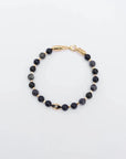 The David Bracelet in 18K Gold laid flat, showcasing its polished gold finish, 6mm black onyx and black labradorite quartz beads, and a single evil eye charm with a black CZ diamond.
