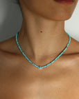 Turquoise evil eye necklace with silver accents worn on model