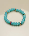 Single Leah turquoise bracelet arranged flat, emphasizing the turquoise beads with pink and gold dividers and a central eye charm for a unique, balanced design.