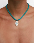 Model wearing MyAleph Lola Cord Necklace with turquoise blue cord and gold evil eye pendant