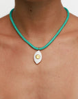 Model wearing MyAleph Lola Cord Necklace in Safran with turquoise cord and gold evil eye pendant