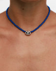 Model wearing MyAleph Luna Cord Necklace with cobalt blue cord and silver evil eye pendant