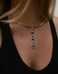 Mayra Evil Eye Necklace with three pendants on a person wearing a black top