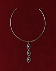 Gold Mayra Evil Eye Choker necklace with a three pendants on a red background