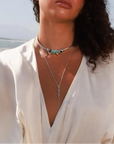 Model wearing MyAleph Large Pampelonne Denim Pouch with mini turquoise phone charm, Terre Choker Necklace, and Mayra Body Chain in a summer beach look