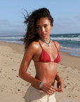 Model wearing MyAleph Lola Cord Necklace in a summer beach look, turquoise blue cord necklace with gold evil eye pendant