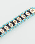 Close-up of MyAleph Riviera Bracelet with glossy turquoise and yellow enamel beads, cotton cord, and adjustable clasp