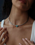 Model wearing the Terre necklace with interchangeable gemstone charms, styled as a modern elemental statement necklace.
