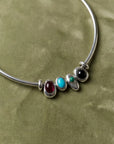 Terre necklace styled with all four interchangeable gemstone charms representing the elements of fire, water, earth, and air.