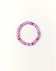 Lavender quartz beaded bracelet with gold spacer details photographed in a full flat lay on a soft cream background