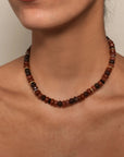 The Valerie Necklace in Espresso styled on a model's collarbone, emphasizing its earthy tones and timeless elegance