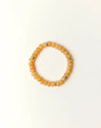 Zoe Tangerine quartz beaded bracelet with gold spacer details photographed in a full flat lay on a soft cream background