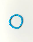 Zoe Azure quartz beaded bracelet with gold spacer details photographed in a full flat lay on a soft cream background