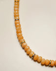 Close-up of the Zoe tangerine quartz necklace, showing detailed facets and golden accent dividers for an elegant touch.
