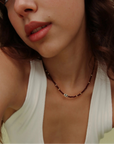 Model wearing the Julianna Necklace in Garnet with a white tank top, showing the bold gemstone contrast against everyday style.