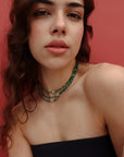 Model wearing the Julianna Necklace in Malachite with a strapless black top, highlighting the bold green beads and evil eye charm.