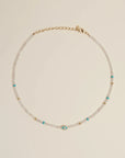 Flatlay of the Julianna Necklace in Moonstone, featuring luminous moonstone beads, turquoise evil eye charm, and gold-plated adjustable clasp.