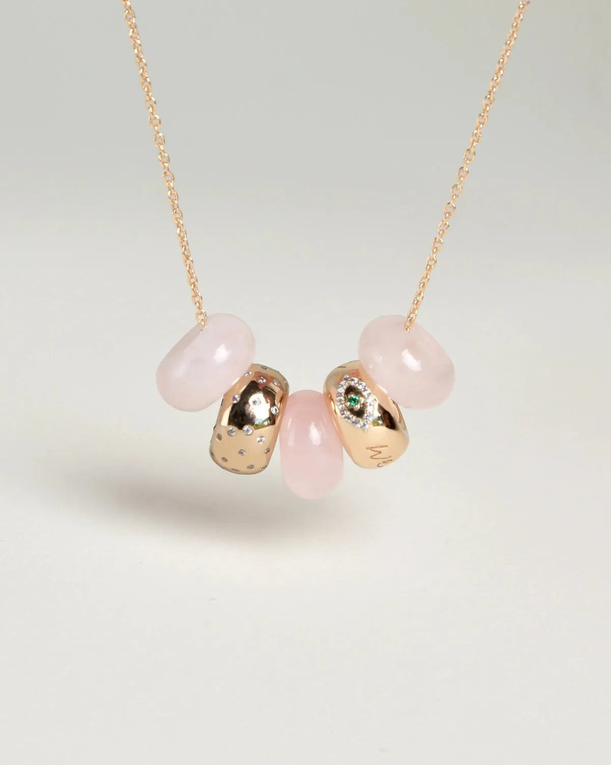 Ava gold necklace with rose quartz beads, evil eye charm, and diamond-detailed charms on a gold chain by MyAleph