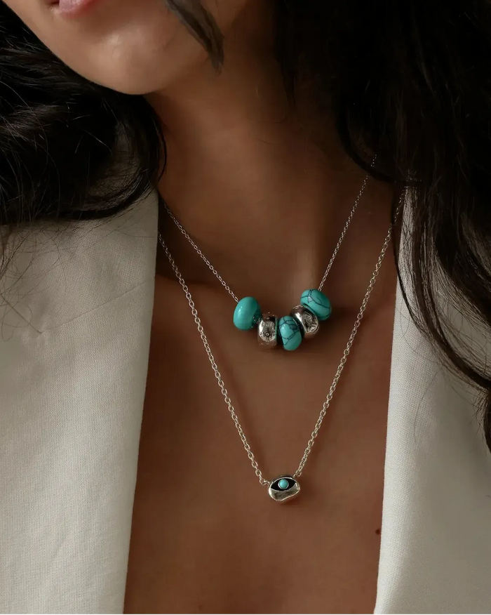 Ava silver necklace layered with the aura evil eye pendant necklace, turquoise beads styled on model by MyAleph