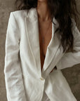 Mayra Evil Eye Body Chain worn on model showing three black enamel evil eye charms resting at chest under open white blazer