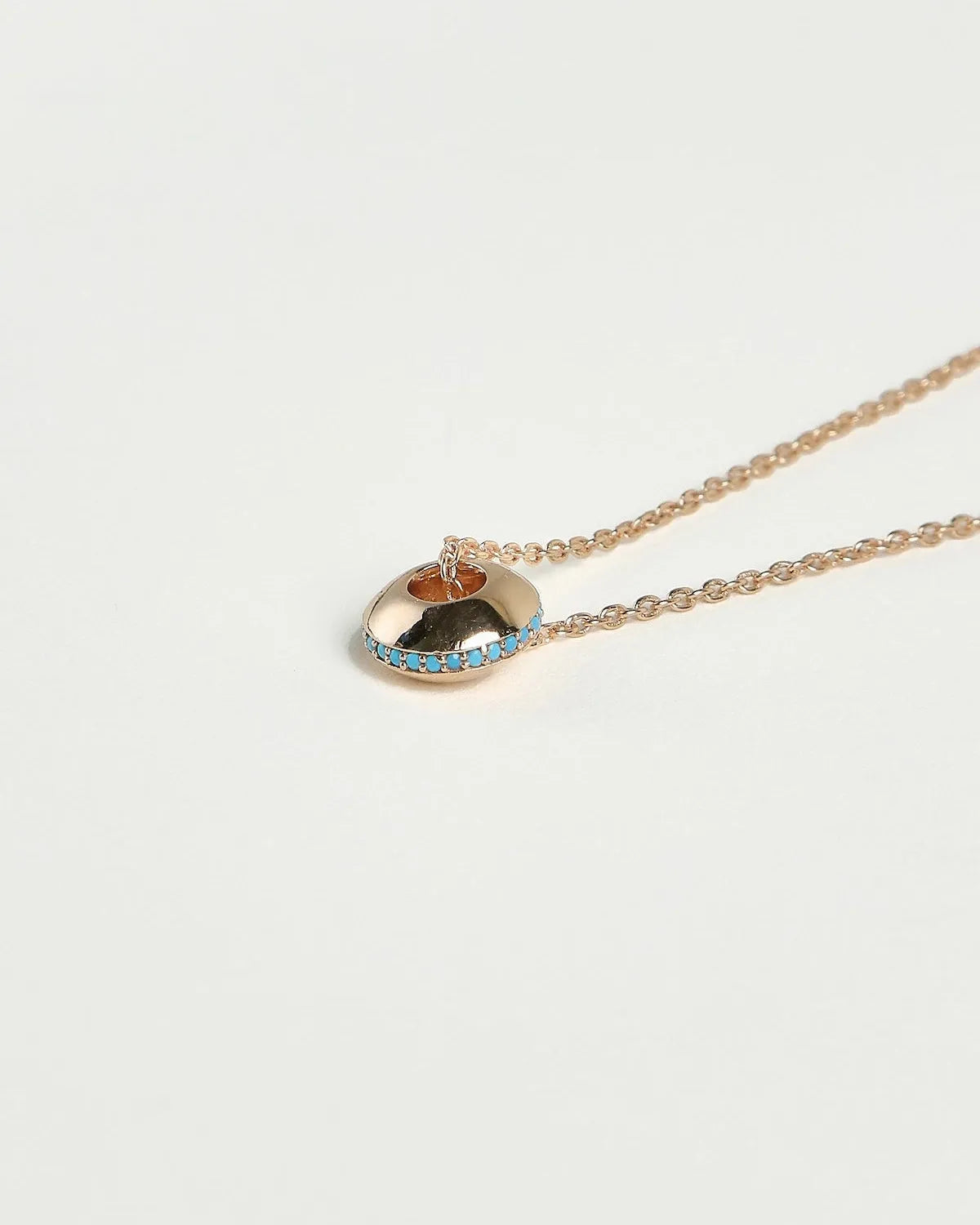 Mia gold necklace with turquoise stone detail around the charm on a gold chain by MyAleph
