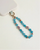 Mini Leah turquoise phone charm with blue beads, purple evil eye charms, and gold details attached to a blush pink phone case