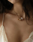 Noa gold charm necklace with rose quartz bead and diamond-detailed charms worn solo on a lace cami by MyAleph