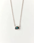 Aura Evil Eye necklace featuring a turquoise gemstone set in a silver tone pendant with premium rhodium plated hardware on a delicate chain.