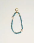 The Stella Bag Charm in Apatite, a luxe accessory handcrafted with semi-precious apatite quartz beads, 14k gold-plated accents, and a zirconia diamond Evil Eye charm, displayed on a neutral background.