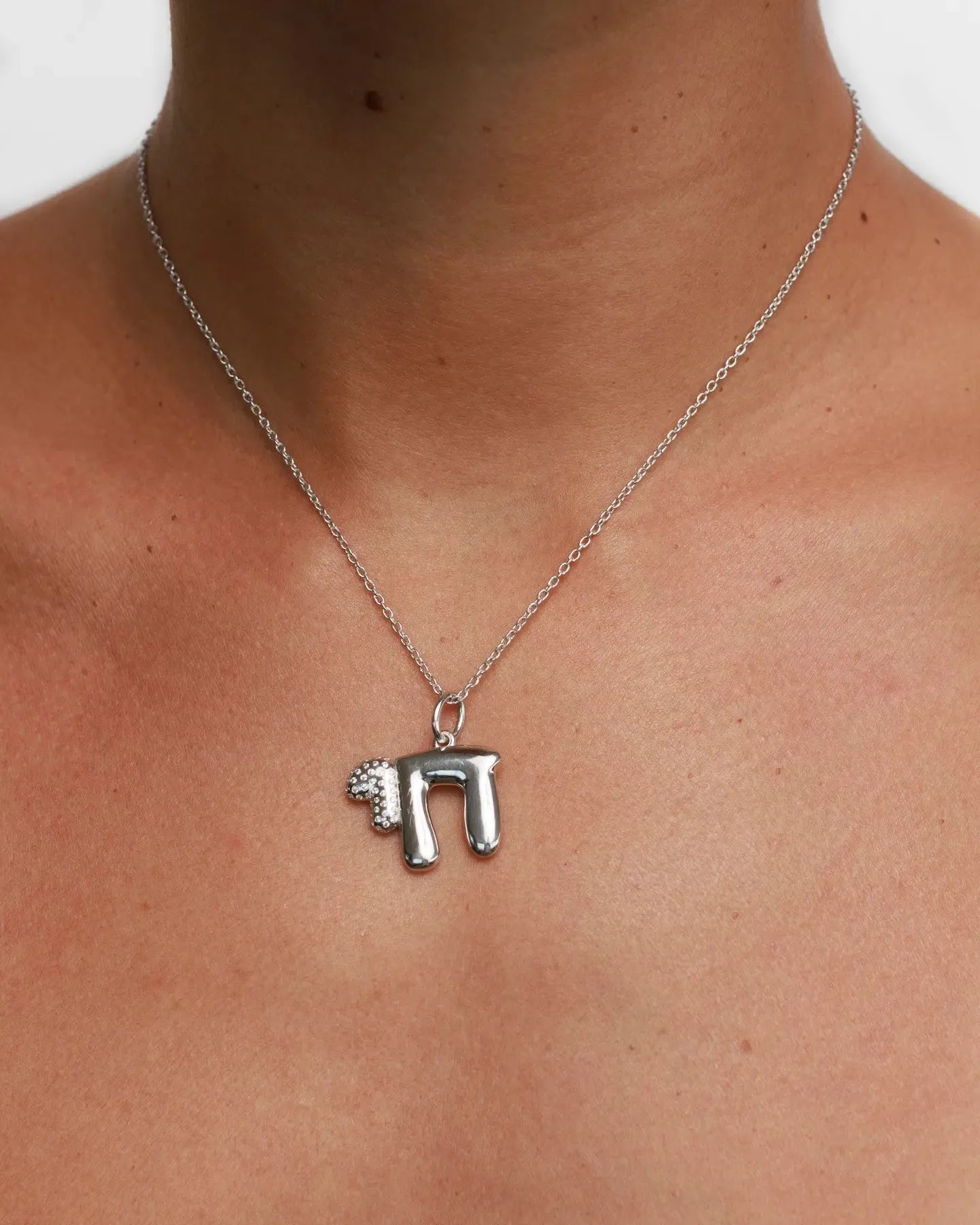 Model wearing MyAleph Chai Necklace, silver Hebrew life symbol pendant with white stone on delicate chain