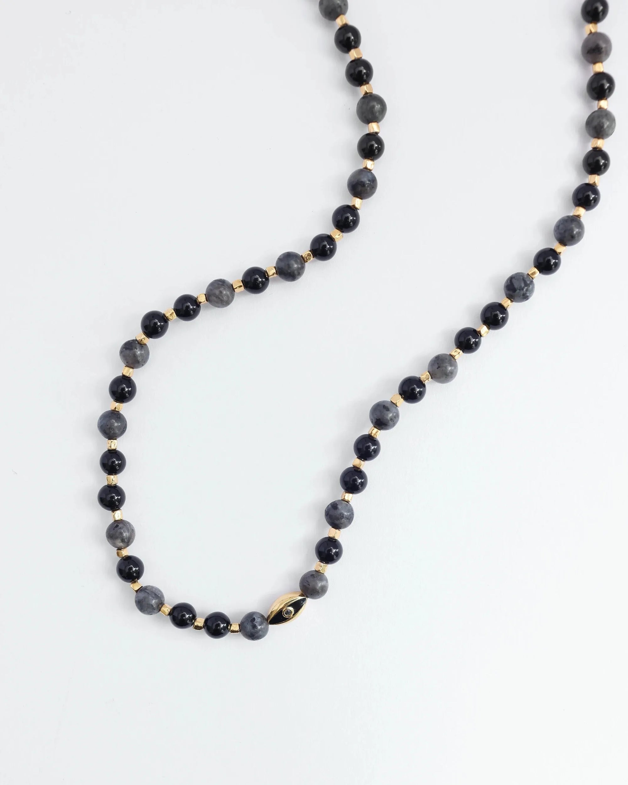 The David Wrap in 18K Gold laid flat in a single strand, highlighting its length and dual evil eye charms with black CZ diamonds.