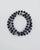 The David Wrap in Silver laid flat and wrapped, showcasing its polished silver finish, 6mm black onyx and black labradorite quartz beads, and dual evil eye charms.