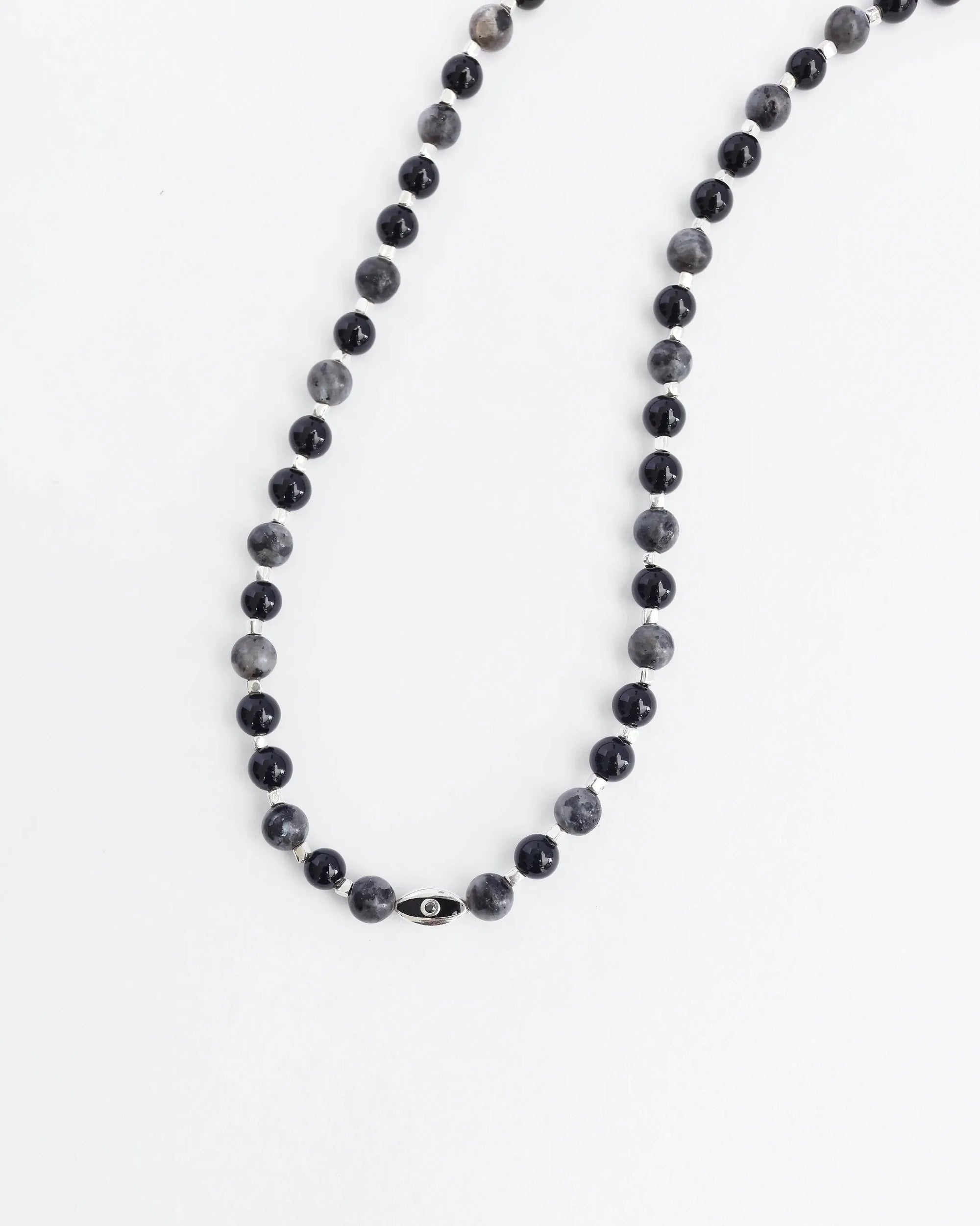 The David Wrap in Silver laid flat in a single strand, emphasizing the length, dual evil eye charms, and polished silver finish.