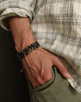  man wearing the David Wrap in 18K Gold as a bracelet, layered with other gold jewelry, emphasizing the piece’s versatility and intentional style.
