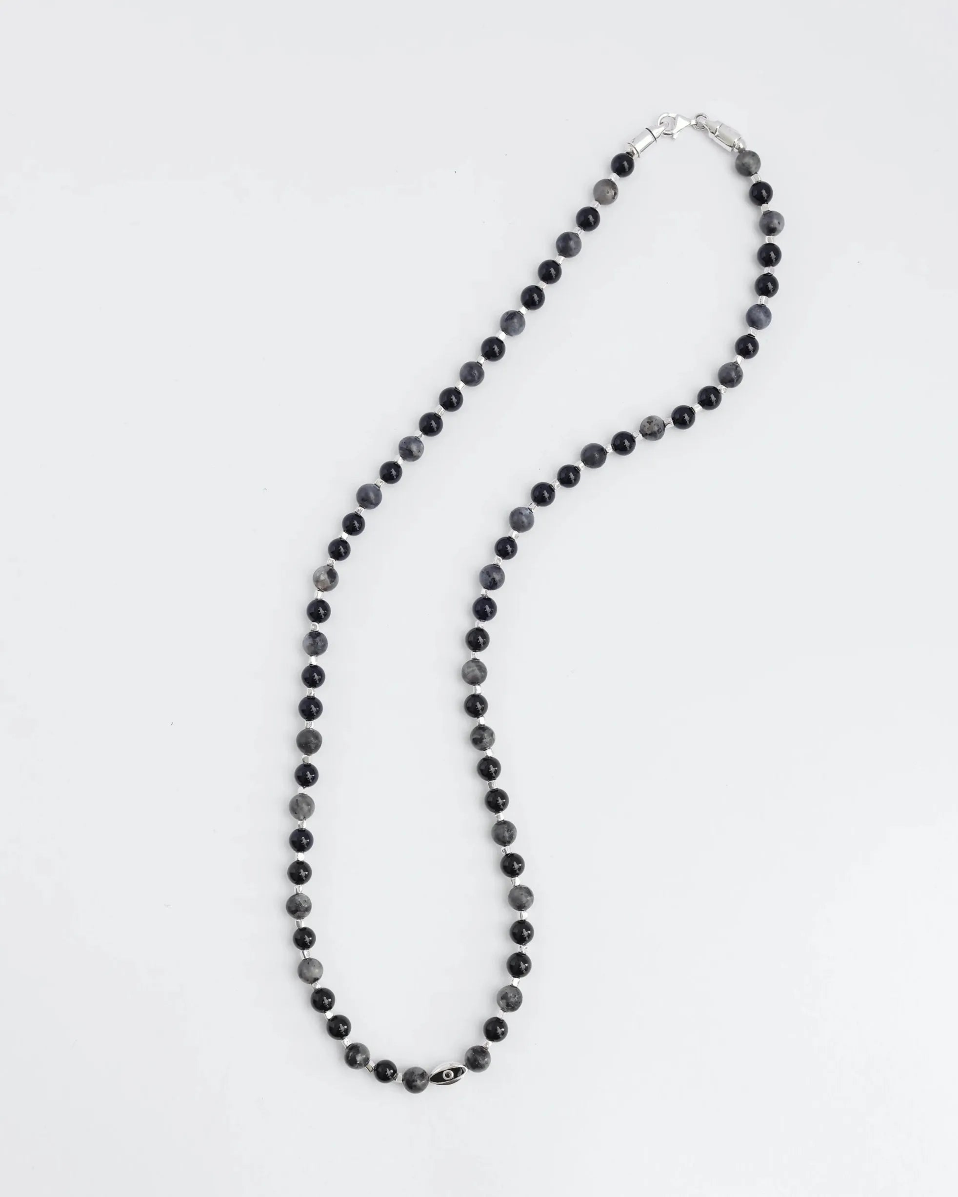 The David Wrap in Silver laid flat in a curved shape, showcasing its length and bead design, featuring 6mm black onyx and black labradorite quartz.