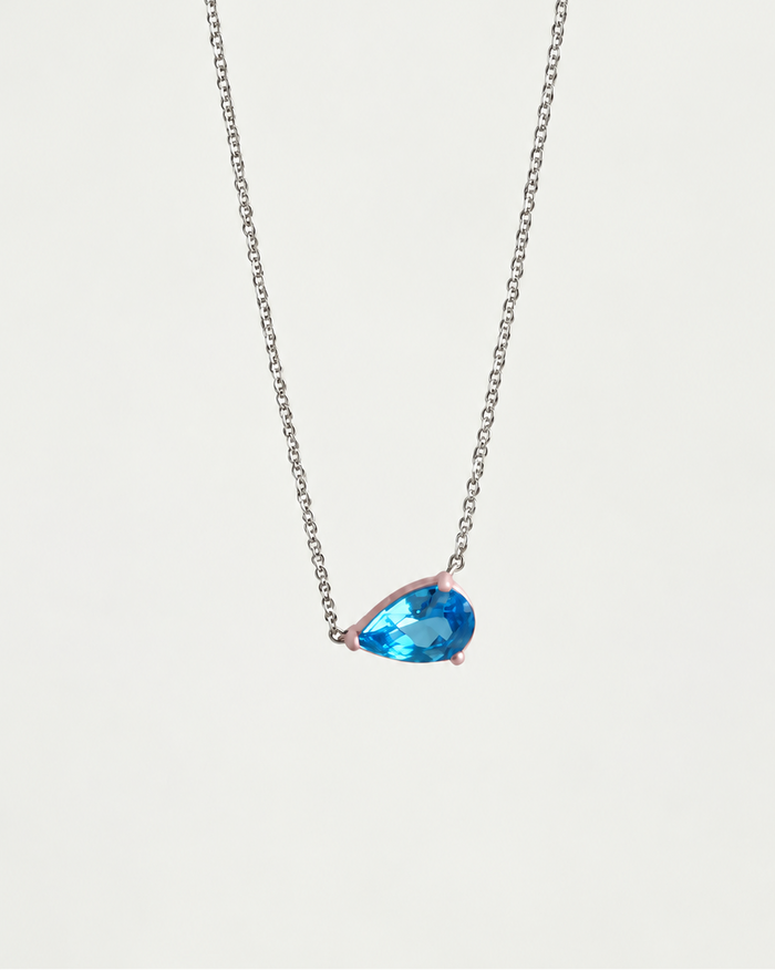 Eden Necklace with a pear cut Blue Topaz Gemstone and baby pink enamel on a silver rhodium-plated chain