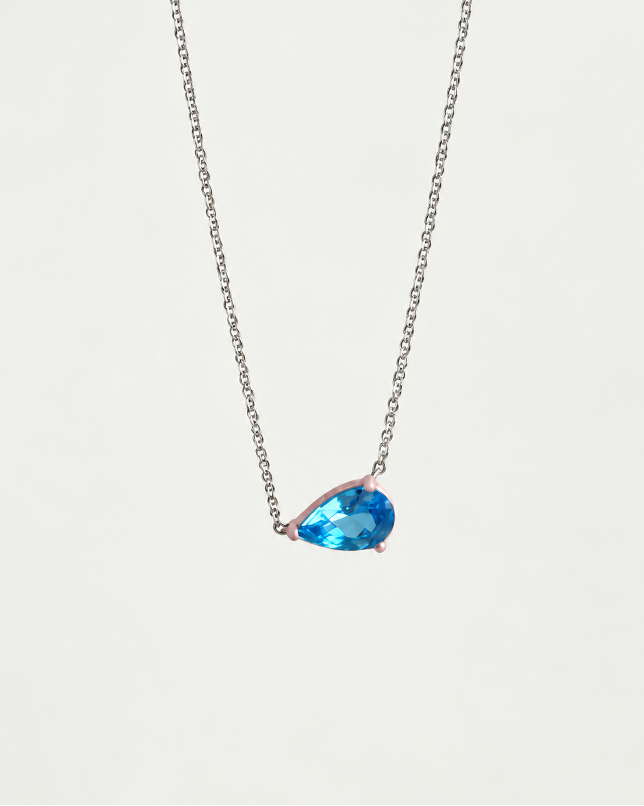 Eden Necklace with a pear cut Blue Topaz Gemstone and baby pink enamel on a silver rhodium-plated chain