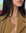 Model wearing the Eden Necklace with a Blue Topaz Gemstone and a tan suede jacket
