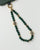 Leah emerald quartz gold phone charm displayed in looped form, highlighting gemstone color and gold finishes.