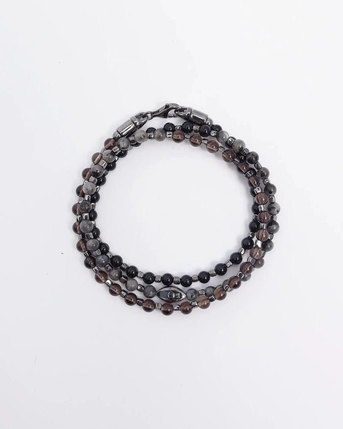  The Ethan Wrap in Silver laid flat and wrapped, showcasing its polished silver finish, 4mm black onyx, black labradorite, and smoky quartz beads, along with dual evil eye charms with black CZ diamonds.