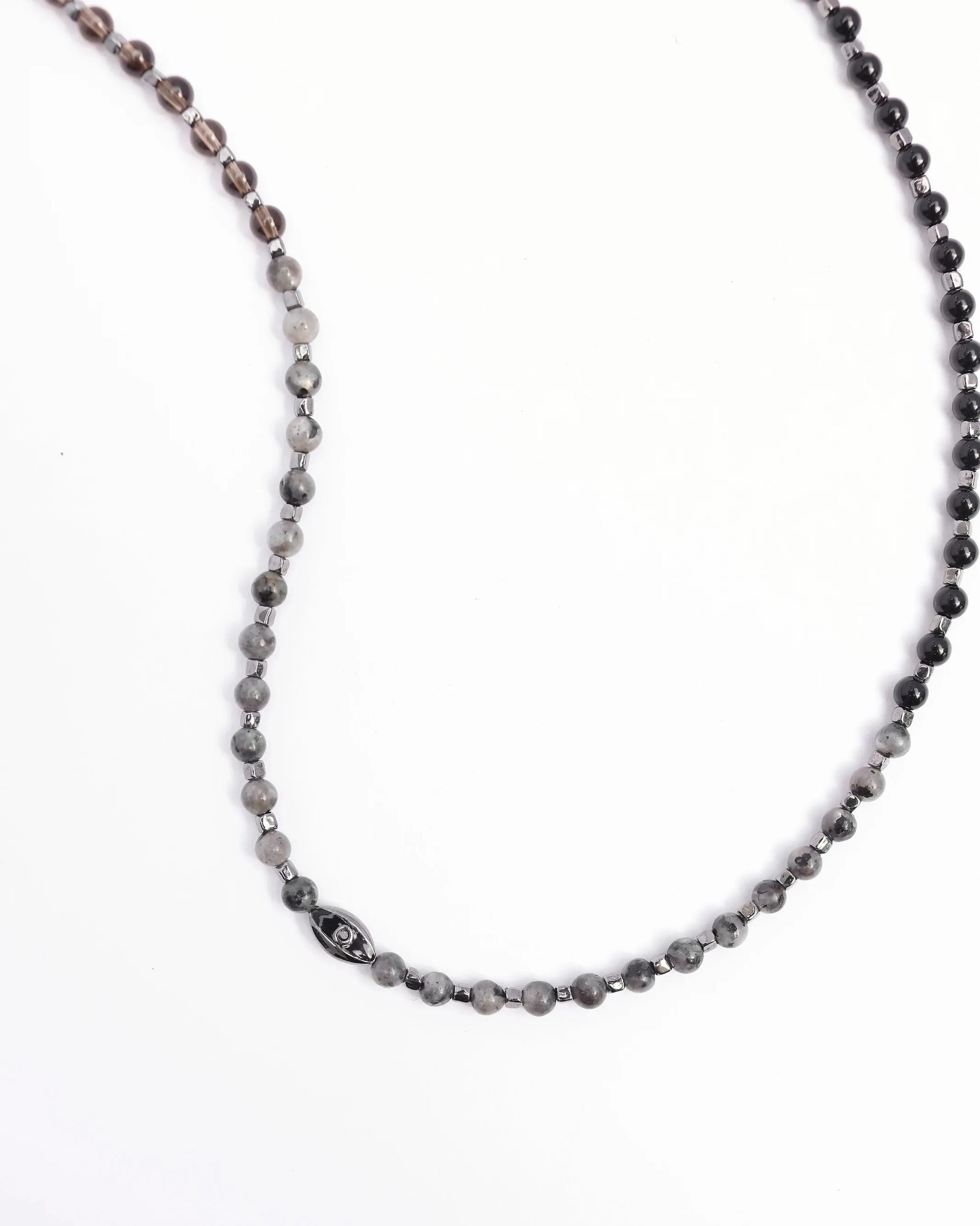 The Ethan Wrap in Silver laid flat in a curved shape, emphasizing the length, dual evil eye charms, and polished silver finish.