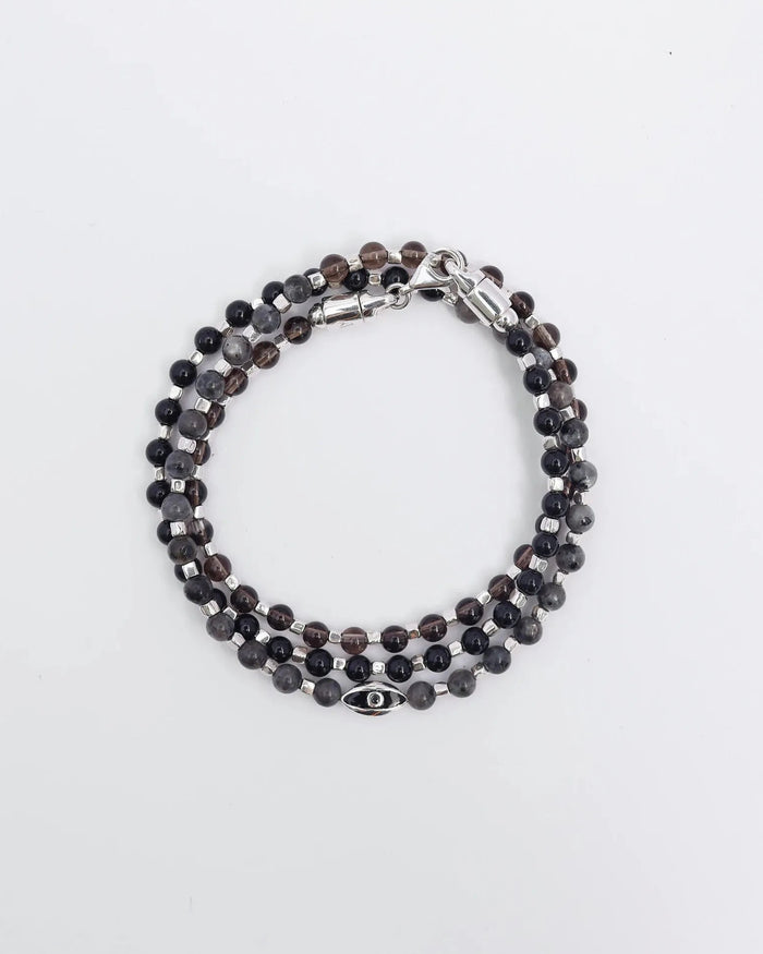 The Ethan Wrap in Silver laid flat and wrapped, showcasing its polished silver finish, 4mm black onyx, black labradorite, and smoky quartz beads, along with dual evil eye charms with black CZ diamonds.