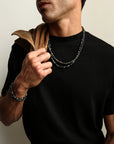 A man wearing the Ethan Wrap in Silver as a necklace over a black t-shirt, highlighting its refined, understated look with subtle stone accents.