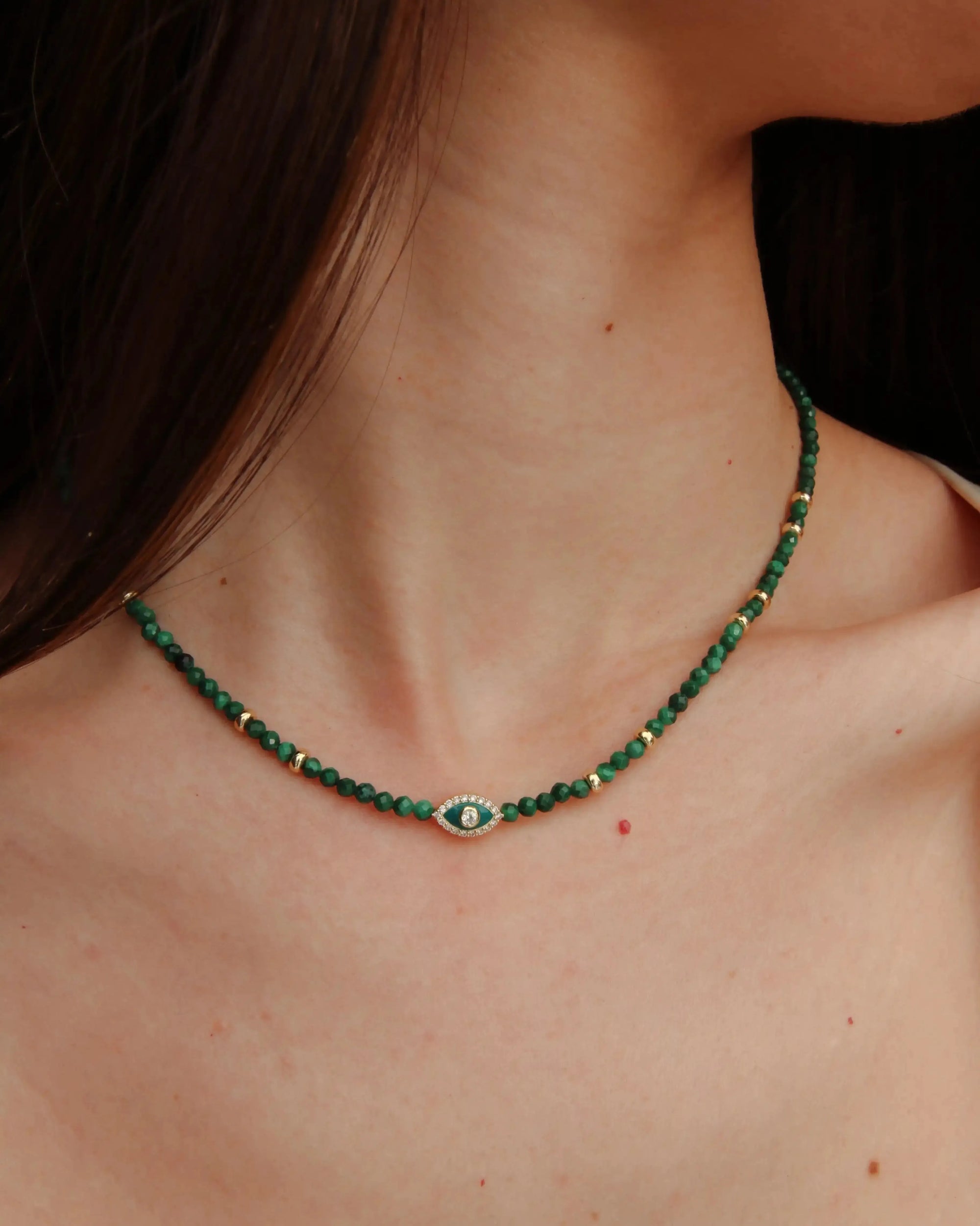 Side view of model wearing the Juliana Necklace in Malachite, showing how the necklace contours the neckline.