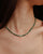 Side view of model wearing the Juliana Necklace in Malachite, showing how the necklace contours the neckline.