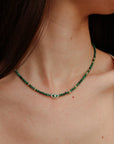 Side view of model wearing the Juliana Necklace in Malachite, showing how the necklace contours the neckline.